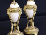 pair of antique gold and white vases on black background