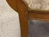 a wooden chair with a striped seat and a chain on the back