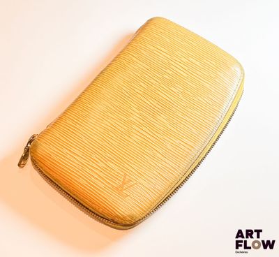 une photo d'un sac à main jaune posé sur une table blanche