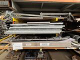 a large pile of metal pipes and pipes in a warehouse