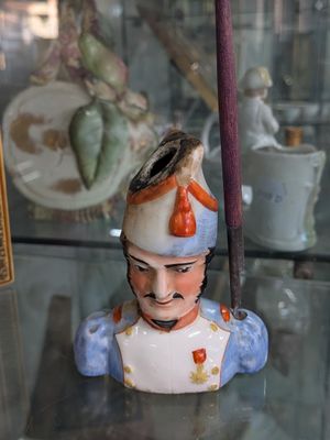 a figurine of a man in a hat on a glass shelf