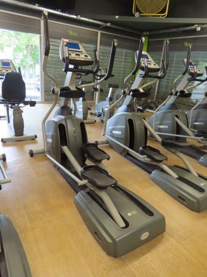 a row of stationary exercise bikes in a gym