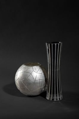 black and white photograph of a vase and a soccer ball on a black background