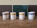 four white and blue coffee cups sitting on top of a wooden table