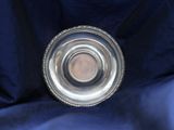 an antique silver plate on a blue cloth with a small hole in the middle