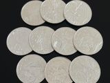 six pièces d'argent de 25 centimes disposées en pyramide sur une surface noire