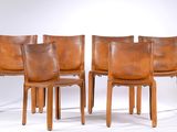 four brown leather dining chairs with wooden legs and backrests