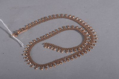 un collier de perles dorées sur un fond blanc