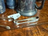 a wooden table topped with silverware and silver spoons