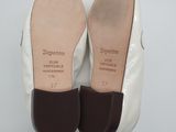 the shoes are white with brown trims and a brown heel