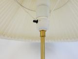 a white umbrella with a black handle on a white wall