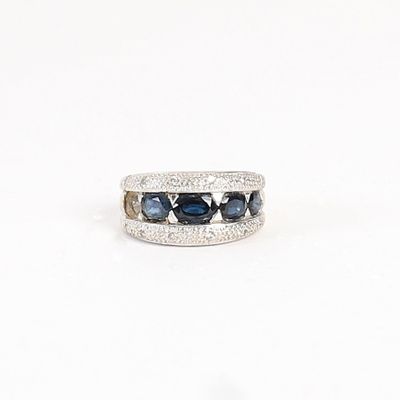 un gros plan d'une bague en or blanc sertie de saphirs bleus et de diamants