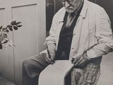 a black and white photo of an old man holding a piece of paper