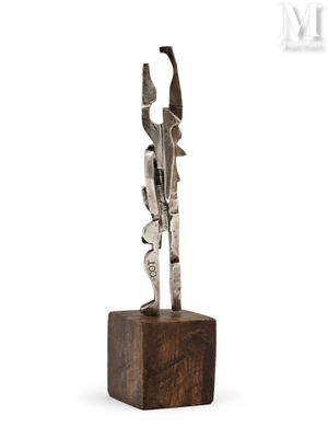 a close up of a metal sculpture on a wooden block