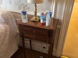 une petite table sur laquelle se trouve une lampe, dans une chambre