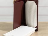 a close up of a notebook and pen on a wooden table