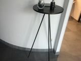 a small table with a vase on it in the corner of a room