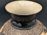 a black and white vase with an elephant design on it
