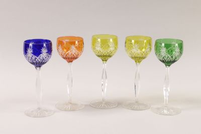 four different colored wine glasses are lined up on a white surface