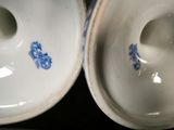 two white and blue vases with blue designs on them
