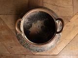 a brown pot sitting on a wooden floor next to a wooden floor