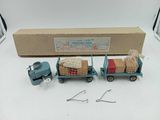 a blue toy truck with luggage on the back of it