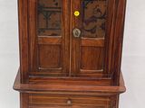 une petite armoire en bois munie d'une porte vitrée