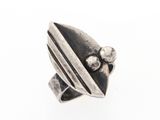 gros plan d'une bague en argent sur une surface blanche