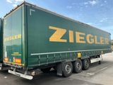 un gros camion vert garé sur un parking