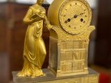 une horloge en or posée sur une table en bois