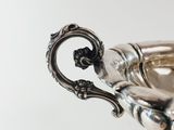 an antique silver plated bowl with a handle on a stand