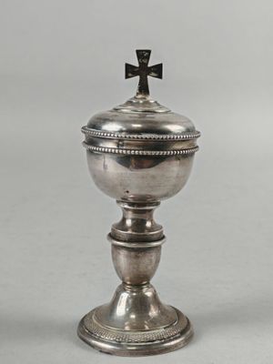 une image représentant une coupe en argent surmontée d'une croix