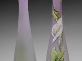 two vases with flowers painted on them sitting next to each other