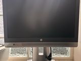 a computer monitor sitting on a desk in front of a window