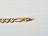 a close up of a gold chain on a white surface
