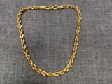 un collier à chaîne en or avec un maillon sur fond gris