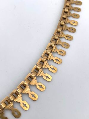 an image of a gold necklace with a chain that has a number of letters on it