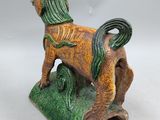 a figurine of a dog that is standing on a rock