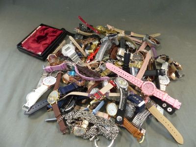un tas de montres diverses et d'autres montres posées sur un lit