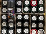 many cans of paint in a box with labels on them