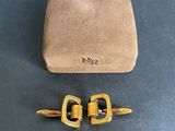 a pair of gold tone cufflinks and a brown sued case