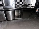 une photo d'une cuisine aux murs à carreaux noirs et blancs