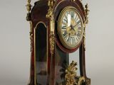 a clock that has a bird on top of it