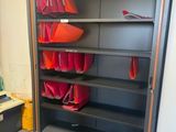 une bibliothèque sur laquelle sont posés plusieurs sacs rouges