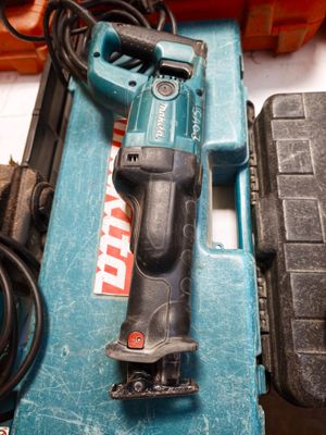 a corded drill sitting on top of a blue tool box