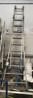 une photo d'un homme debout sur une échelle dans une usine