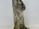 concrete statue of a man with his arms crossed in front of a white wall