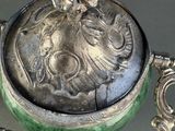 a silver and green box with a flower on it