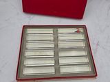 an image of a red box with six silver trays in it on a marble surface