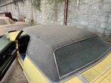 a yellow car parked in a garage next to another car